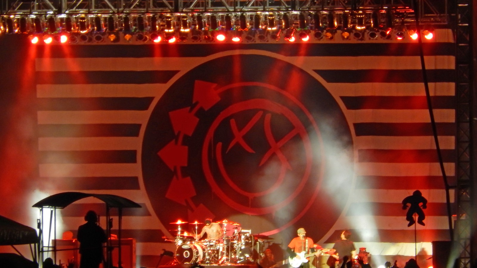 blink-182 en vivo en el Riot Fest de Chicago, 2013, frente a su clásico logo sonriente